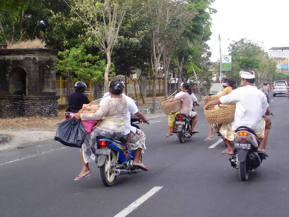 Balinese with offerings on motor scooters