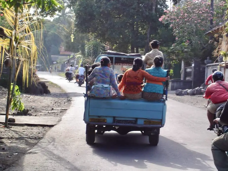 well-dressed Balinese woman in the back of a pick-up truck