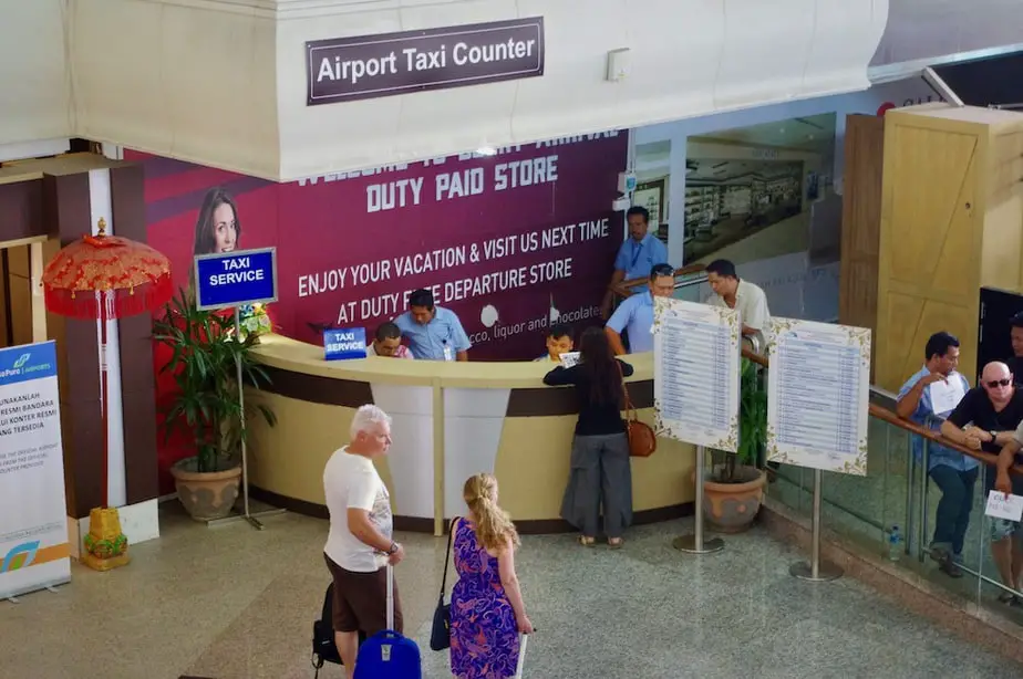 tourists waiting at the airport taxi counter at Ngurah International Airport in Bali