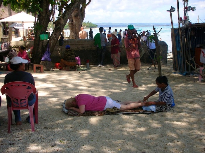 Balinese woman giving a massage on the beach in Sanur