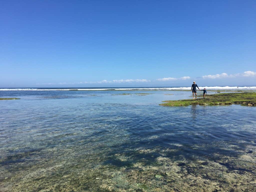 walking between the rocks during low tide in search of sea life at Balangan beach