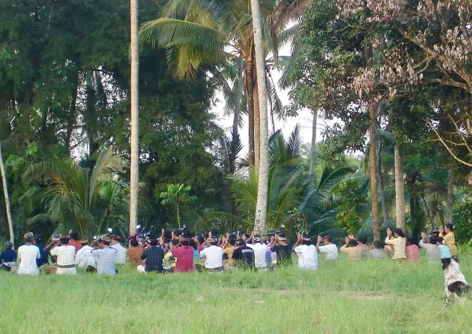 Balinese men praying near a shrine