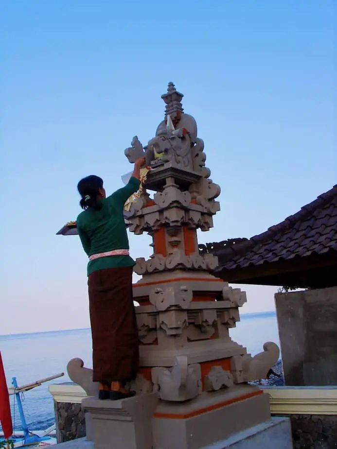 placing offerings on a shrine in Amed Beach
