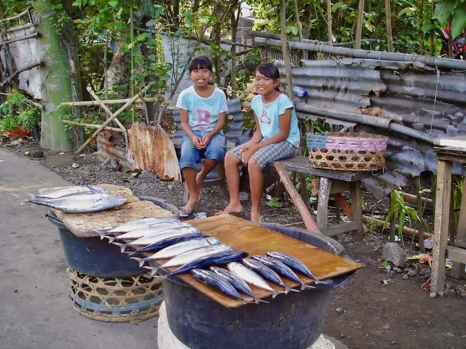 small kids selling fresh fish near padangbai beach