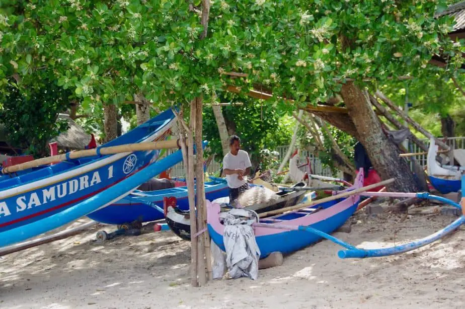 Balinese fisherman repairing his nets at Jimbaran Beach