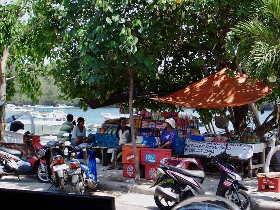 selling snacks under the trees at Padangbai Beach