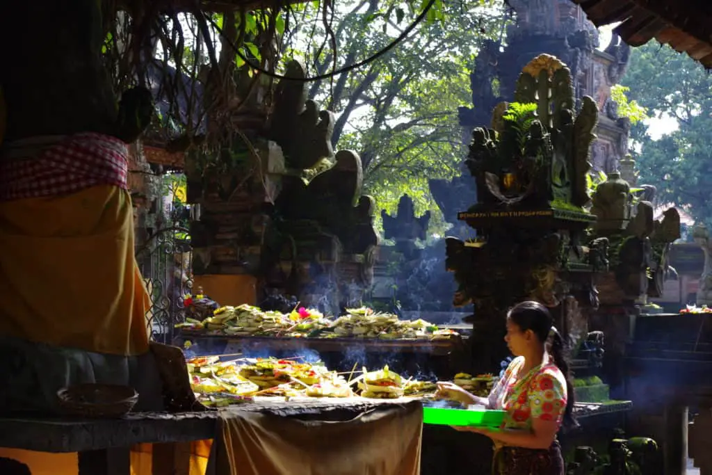 Balinese woman placing offerings to Ganesha, the Deity of Good Fortune and Prosperity