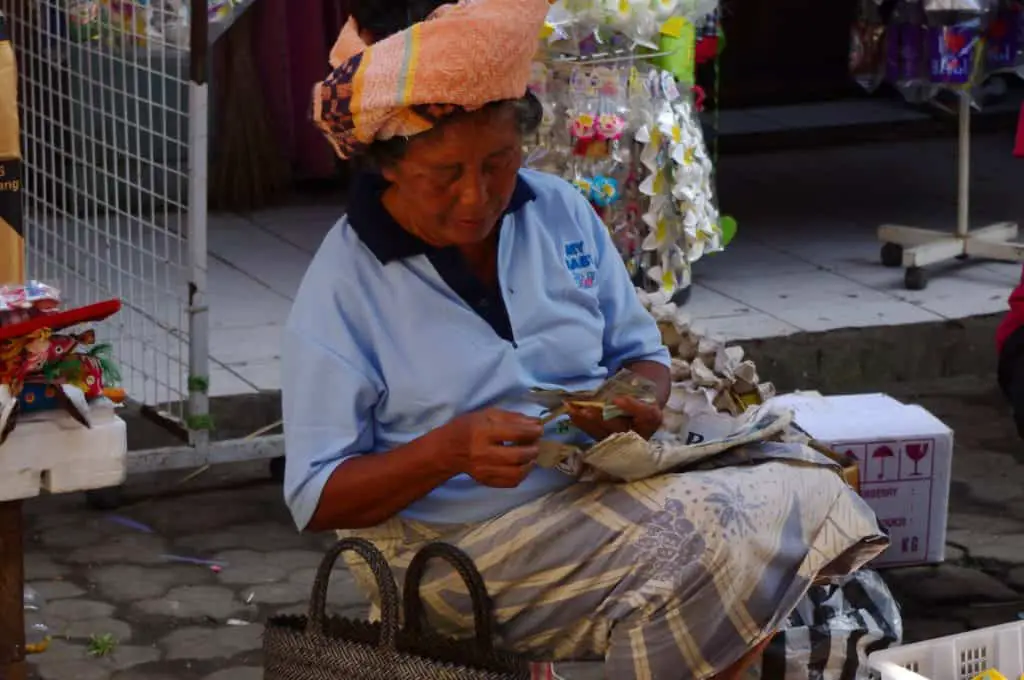 Balinese woman counting her money on the Ubud Market