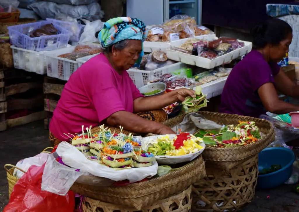 Balinese woman preparing offerings which are for sale on the Ubud market