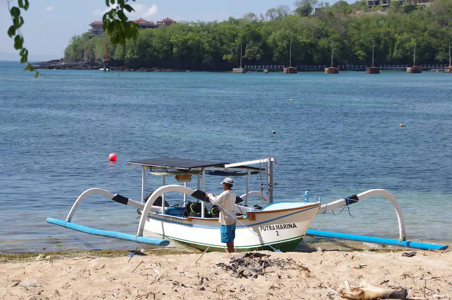 Balinese man maintaining his traditional fishing boat