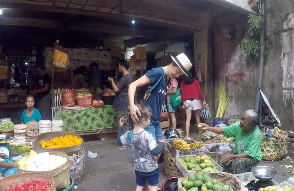 Balinese woman offering a piece of banana to eat 