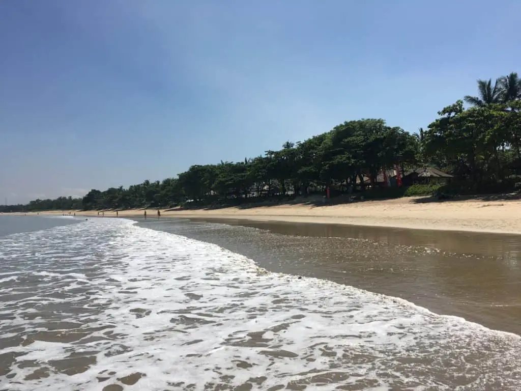 a few people walking on Jimbaran Beach