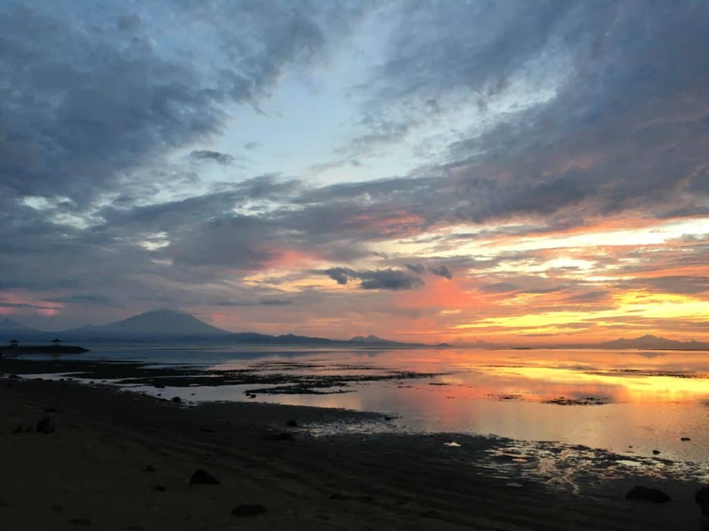 orange and pink colours during sunrise at sanur beach 
