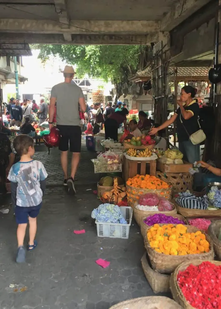 balinese woman selling flowers for offerings at the ubud market