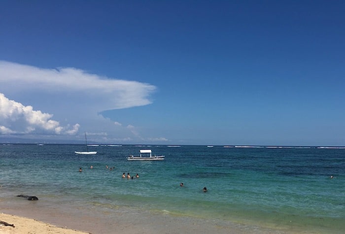 kids swimming at geger beach during low-tide