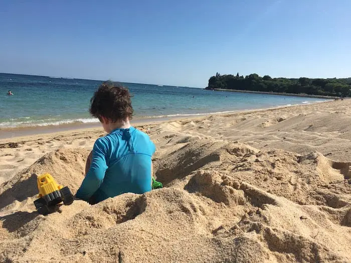 our little boy building sand castles at the beach in bali