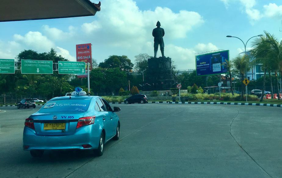 A Bluebird taxi driving near the airport in Bali