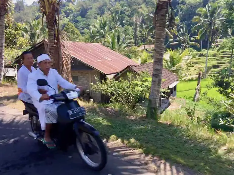 Balinese man and woman on a motor scooter in Wongayagede