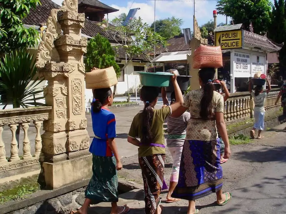 children carrying baskets on their heads in east bali