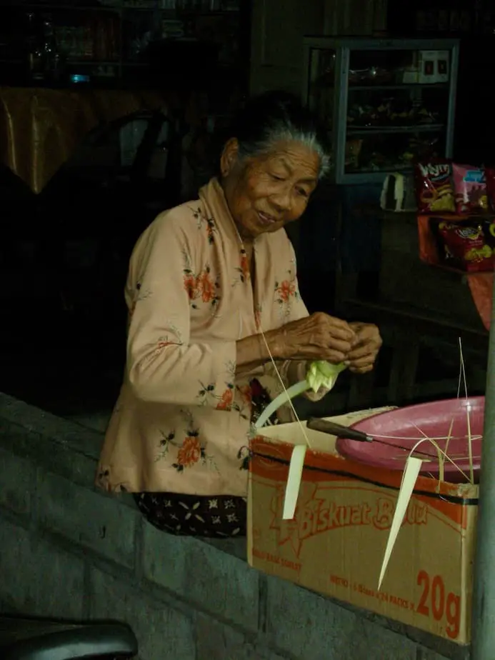 old Balinese lady preparing offerings for the gods
