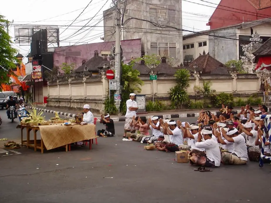 Balinese men sitting on the road while praying